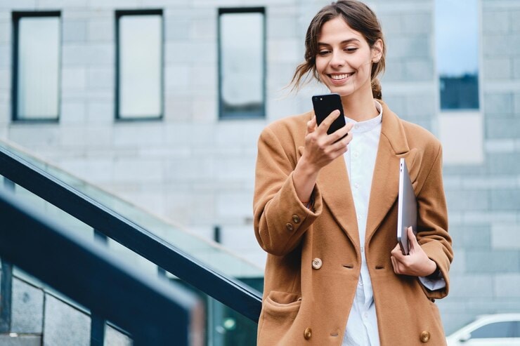 woman smiling and looking at her phone