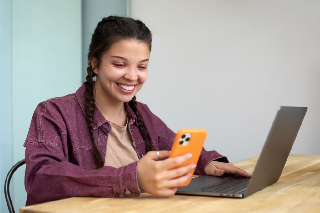 Woman using her phone and laptop