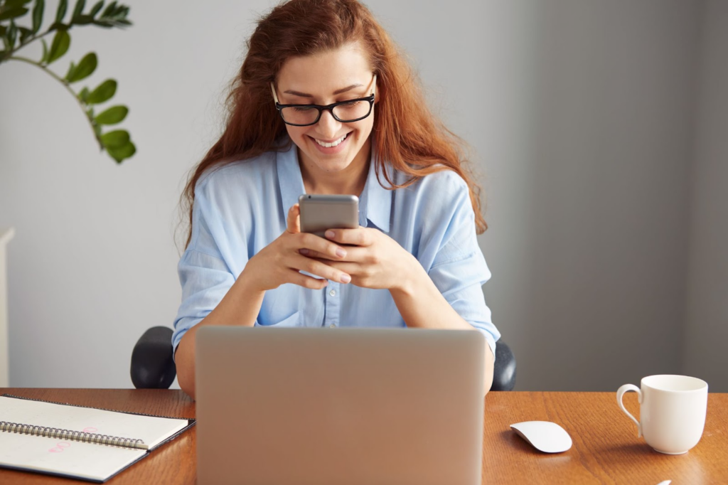 Woman with a smile using her phone in an office