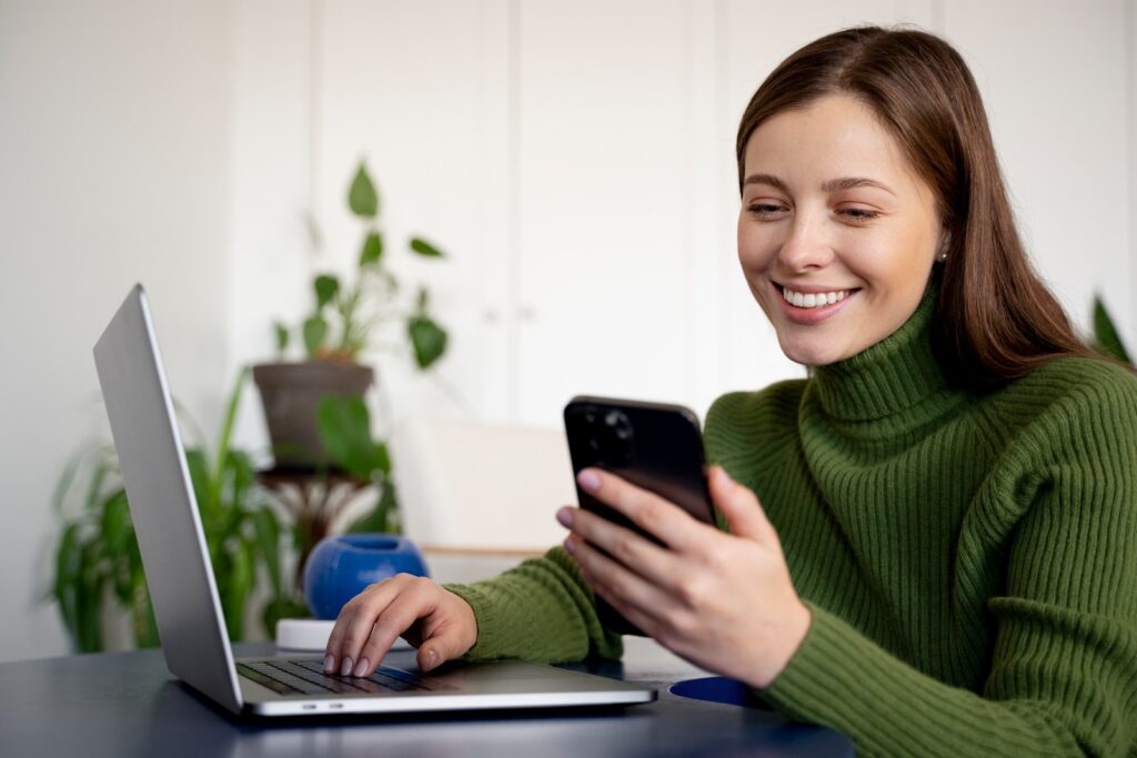 woman using a phone and smiling