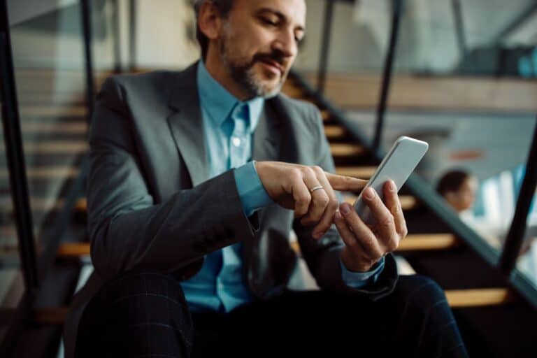 A man sitting while using a phone