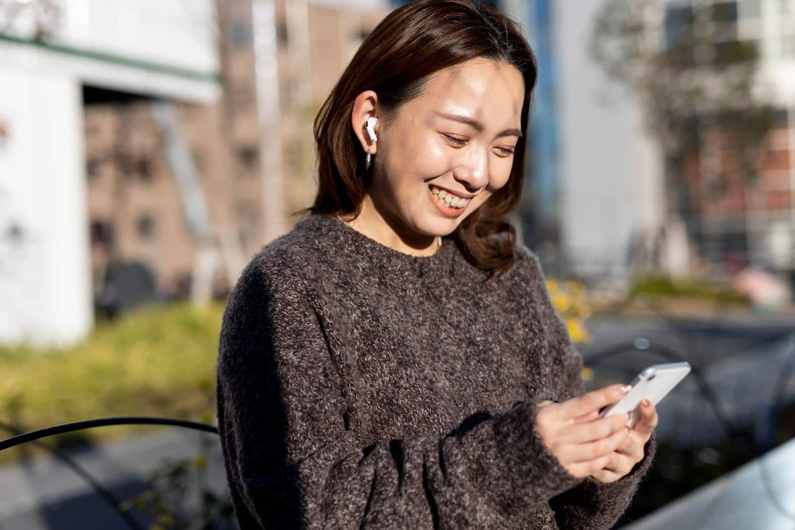 A woman smiling while using her phone