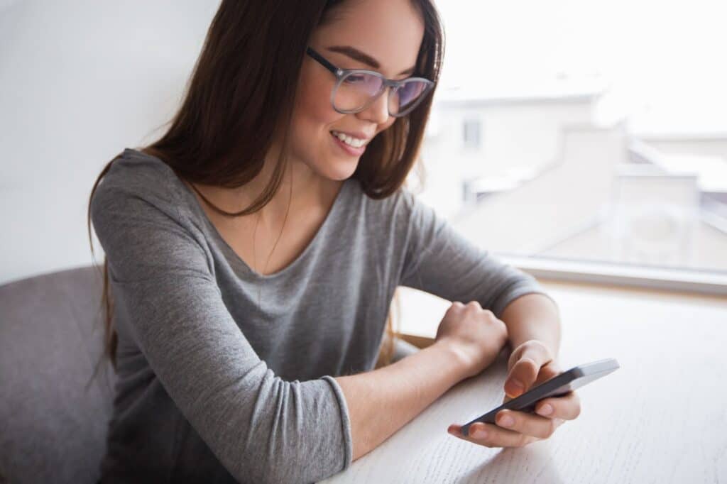 Woman sitting while using her phone