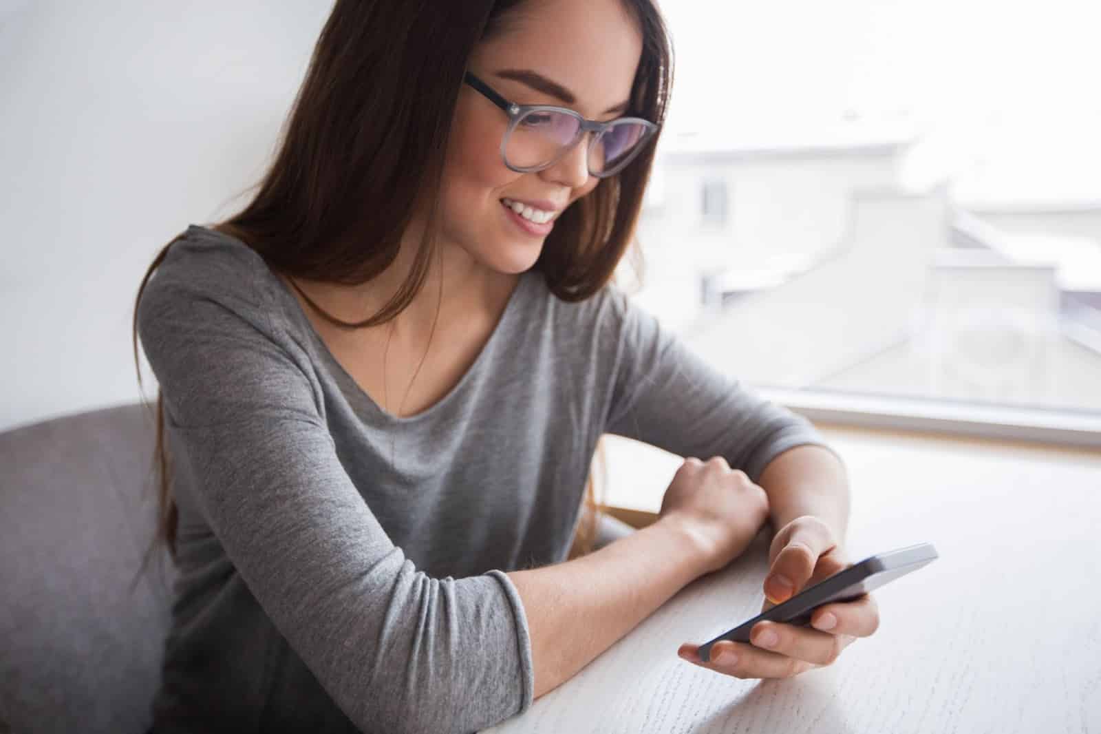 Woman sitting while using her phone
