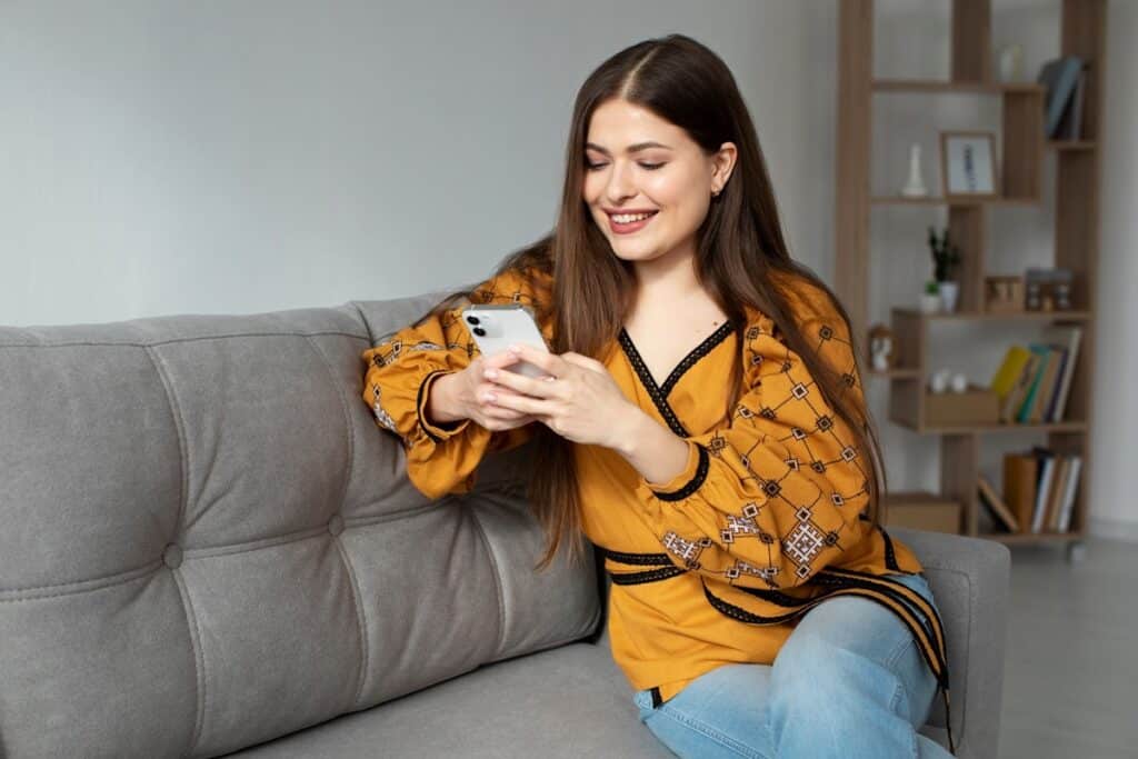 Woman at home reading a text message on her phone
