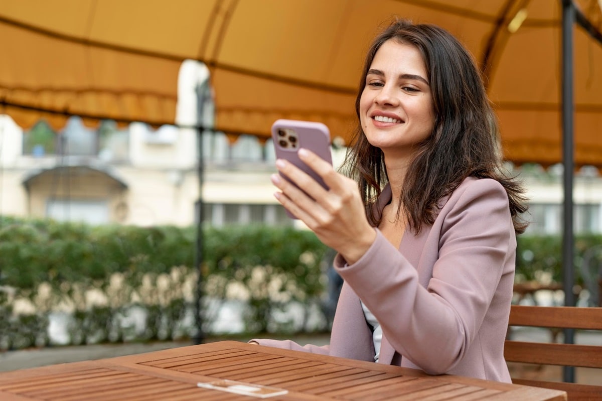 A smiling woman reading an SMS