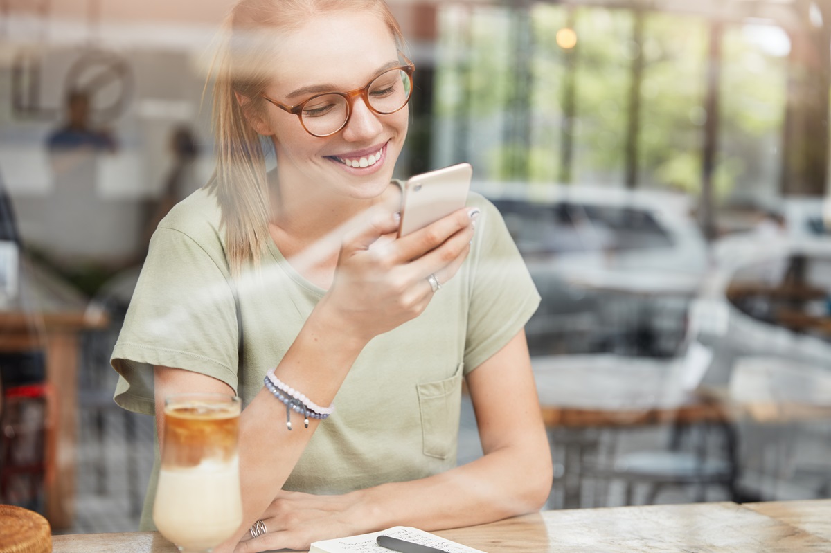 A woman in a cafe reading a text message